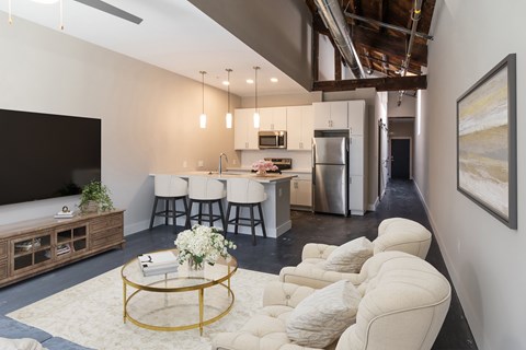 A modern living room with a bar area and a kitchen in the background.