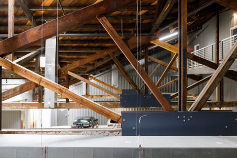 a view of a car parked in a building with wooden beams