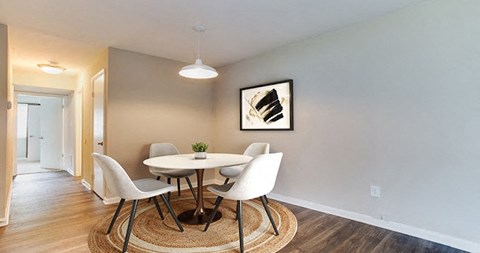 A dining room with a round table and chairs.
