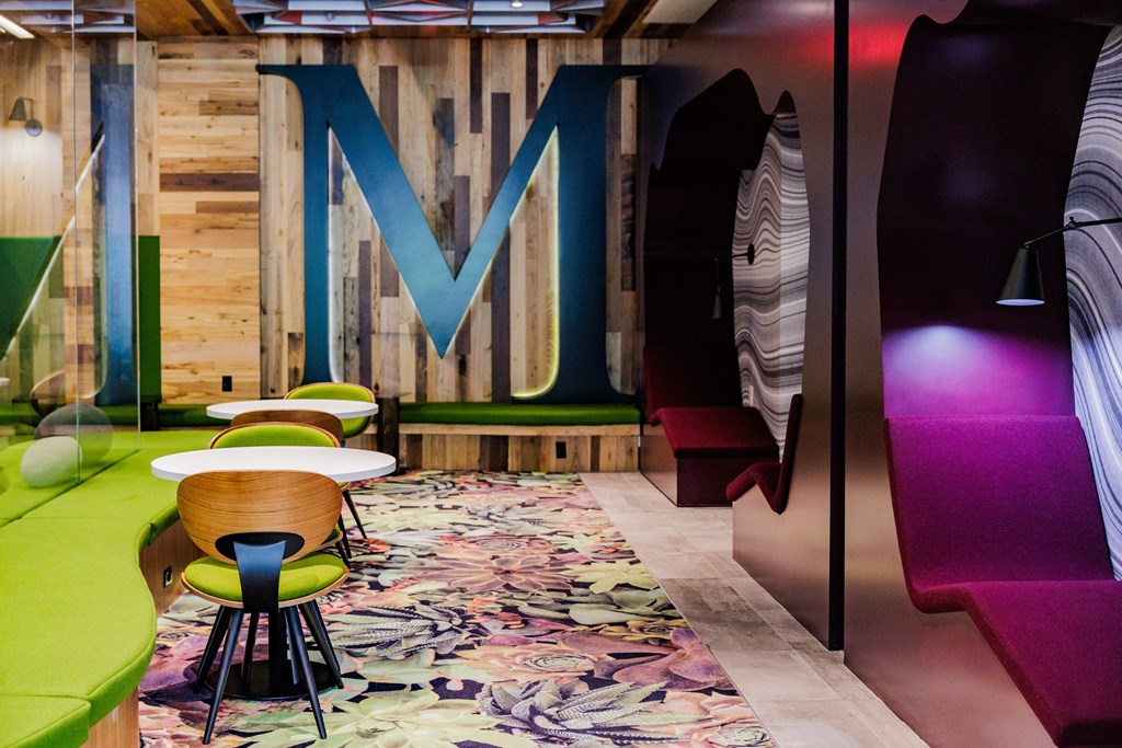 A room with a wooden wall and a large letter M on it.