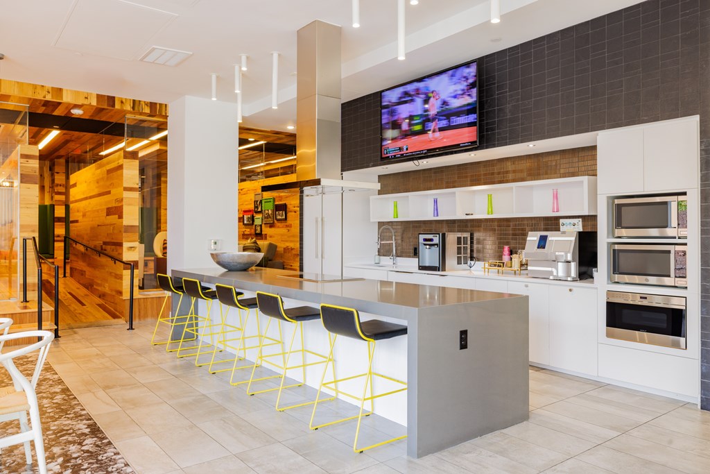 A modern kitchen with a bar area and a television mounted above it.