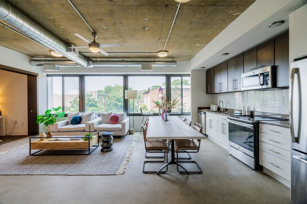 A modern kitchen with a dining table and chairs in the middle of the room.