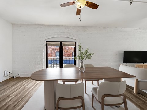 A dining room with a table and chairs.
