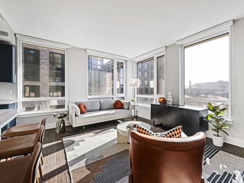 A living room with a brown leather chair and a white couch.