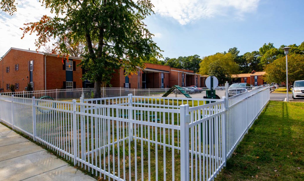 a white fence in front of a playground