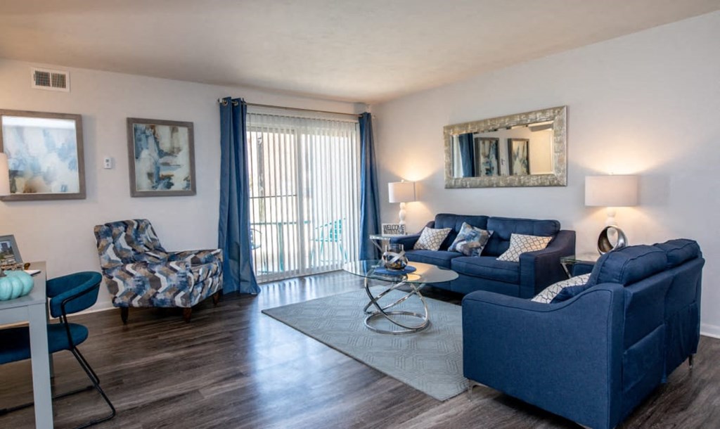 a living room with blue furniture and a sliding glass door