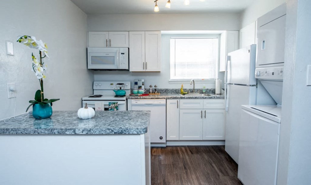 a kitchen with white appliances and granite counter tops