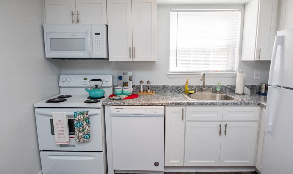 a kitchen with white appliances and granite counter tops