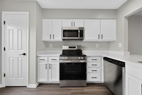 A kitchen with white cabinets and appliances.