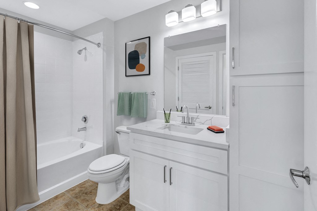 a white bathroom with a shower and a sink and a toilet
