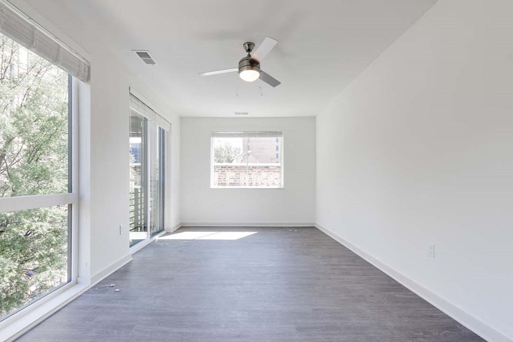 an empty room with a ceiling fan and a window