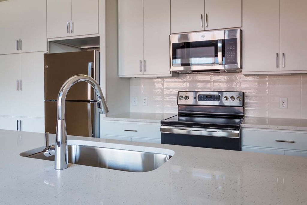 a kitchen with a sink and a stove and a microwave