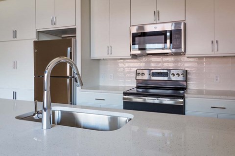 a kitchen with a sink and a stove and a microwave