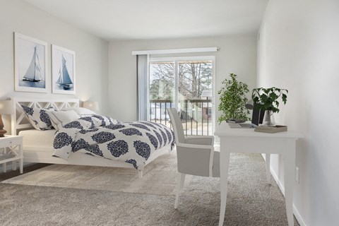 a bedroom with a bed and a white desk and a window