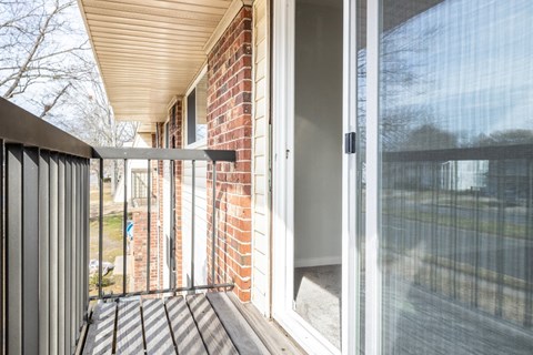 a balcony with sliding glass doors and a brick wall