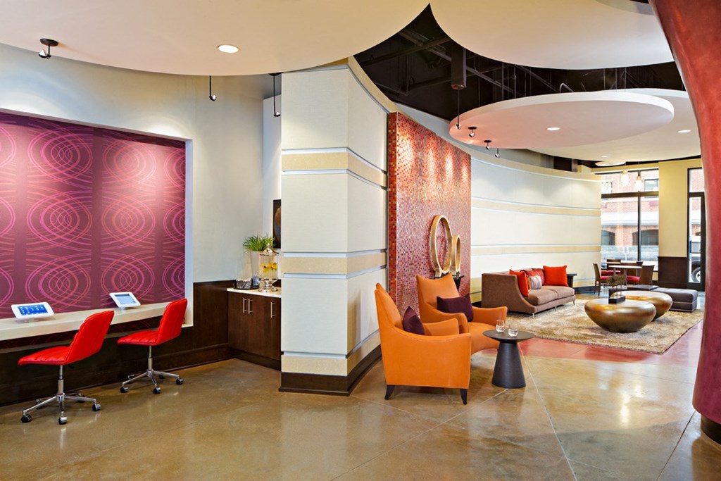 the lobby of a hotel with chairs and a reception desk