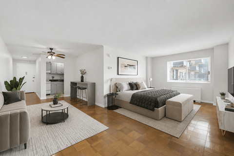 A modern bedroom with a large bed and a living area with a couch.