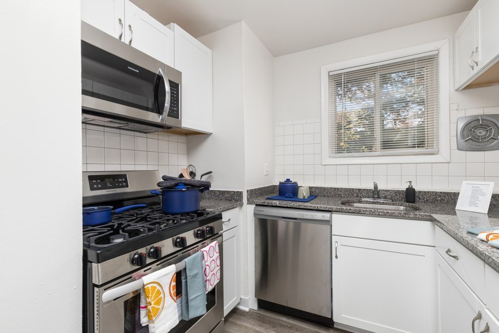 A kitchen with a stove, microwave, and dishwasher.