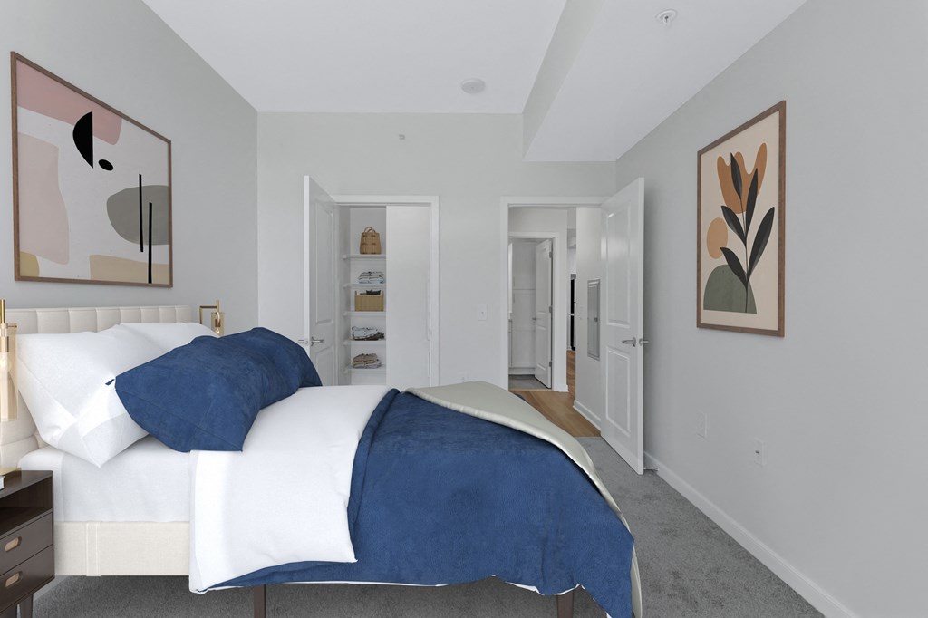 a bedroom with a white bed and a blue blanket    and a closet