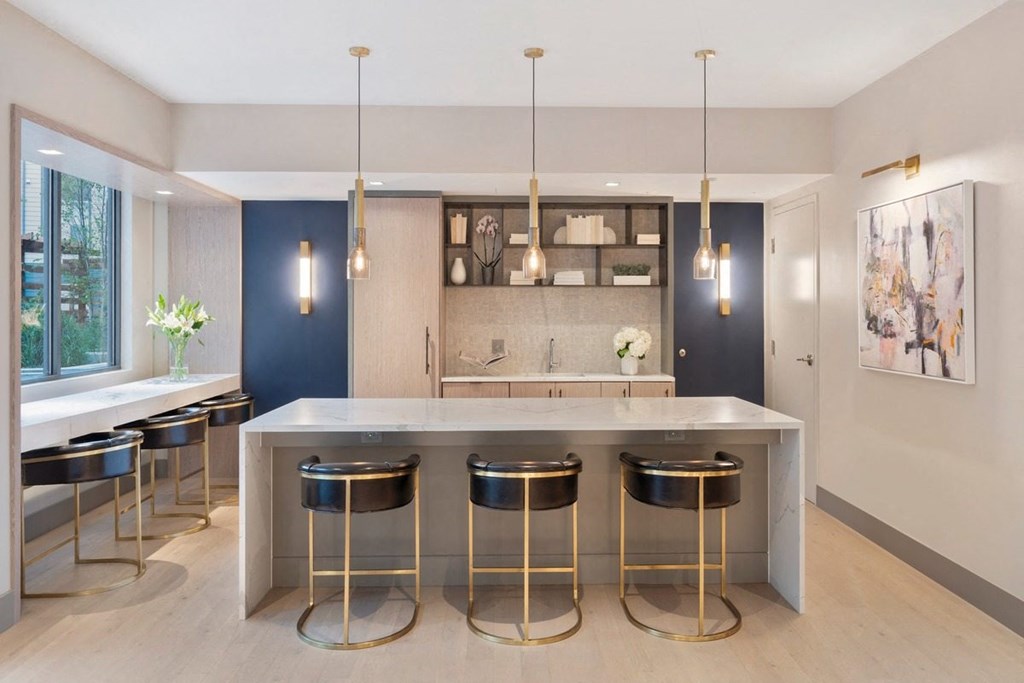 a kitchen with a marble counter top and gold stools