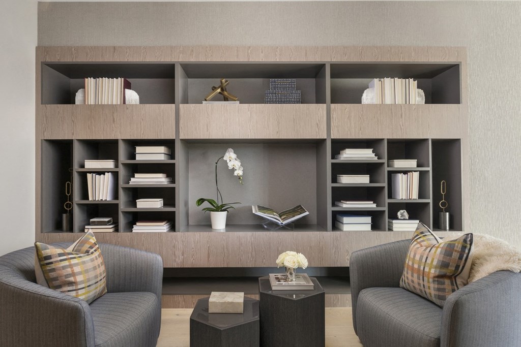 a living room with two chairs and a bookshelf