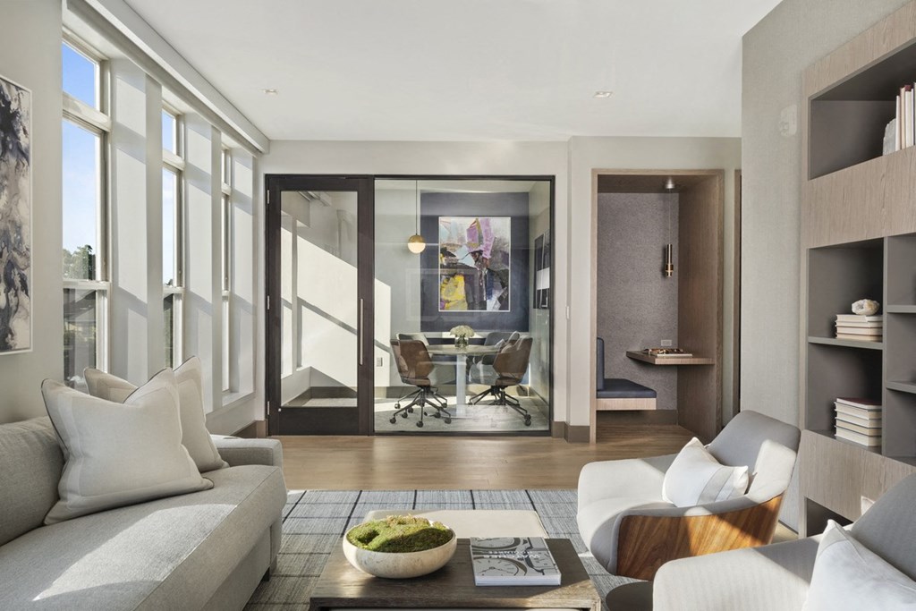 a living room with a couch and a table in front of a window