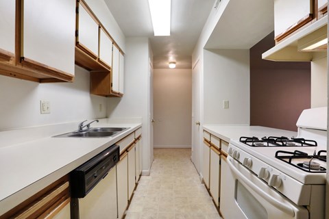 A kitchen with white cabinets and a white stove top oven.