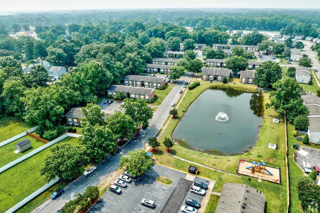 an aerial view of a neighborhood with a pond and parking lot