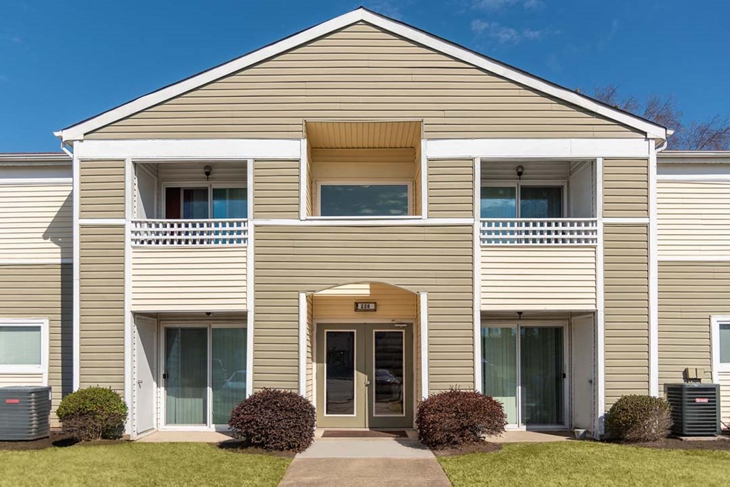 A two-story building with a beige facade and a central entrance.
