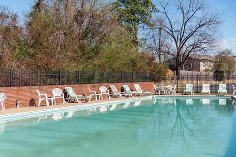 a swimming pool with chairs and chairs around it