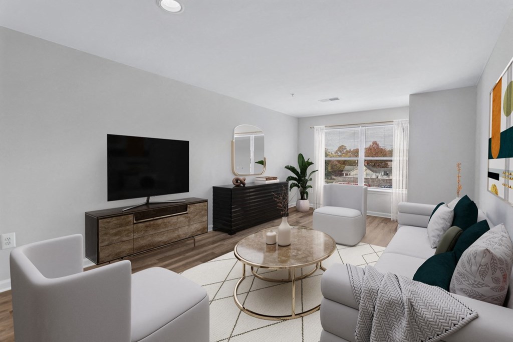 a living room with white furniture and a television