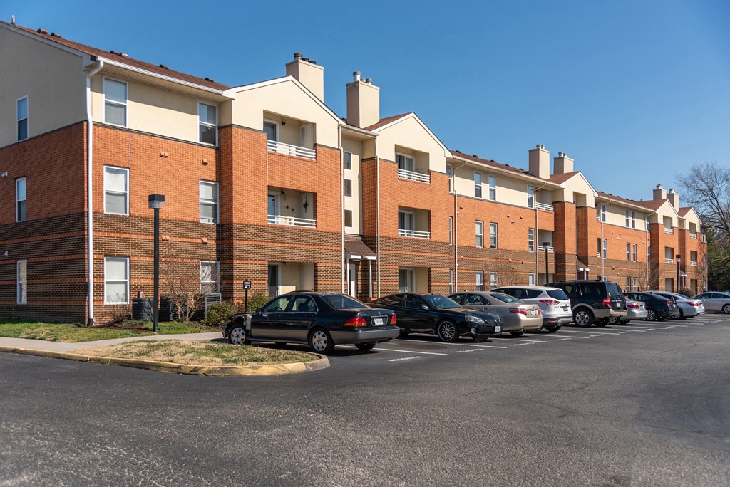 a row of brick apartment buildings with cars parked in front