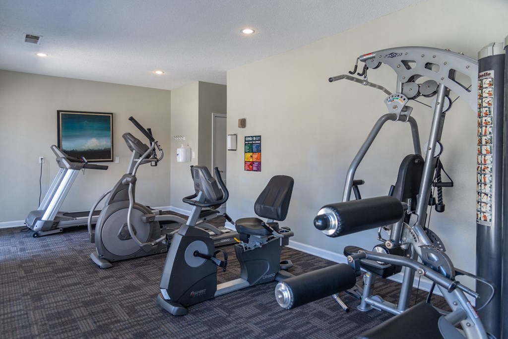 a gym with exercise machines and a tv