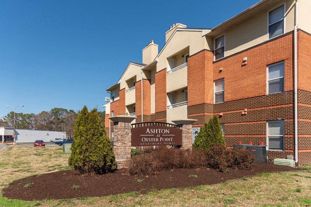 an apartment building with a brick exterior and a sign