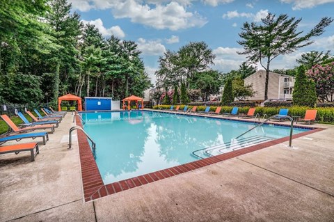 a swimming pool with a bunch of chairs around it