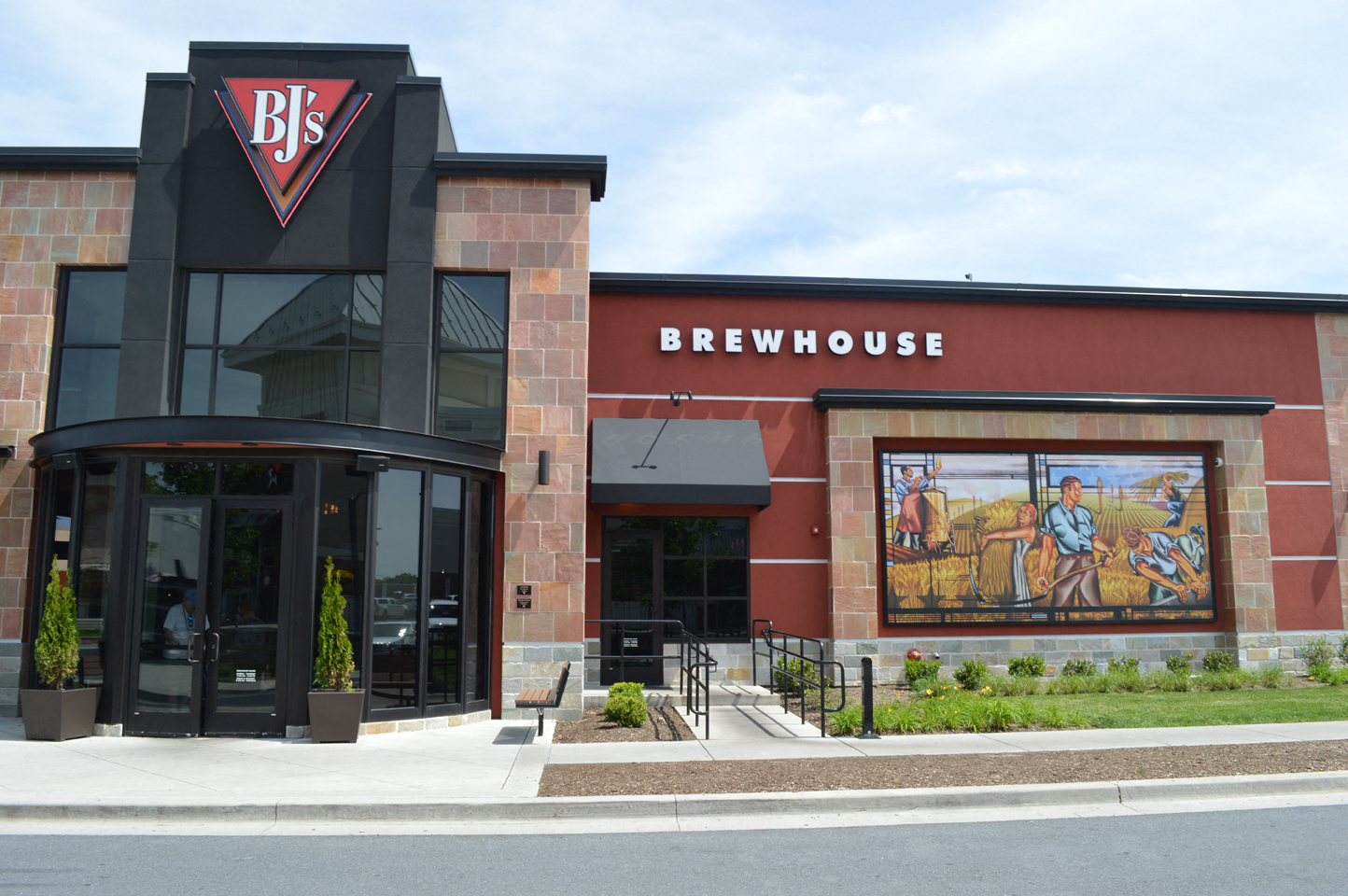 the exterior of a brewery with a mural on the side of the building