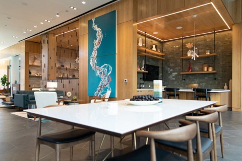 a dining room with a white table and chairs and a blue painting on the wall