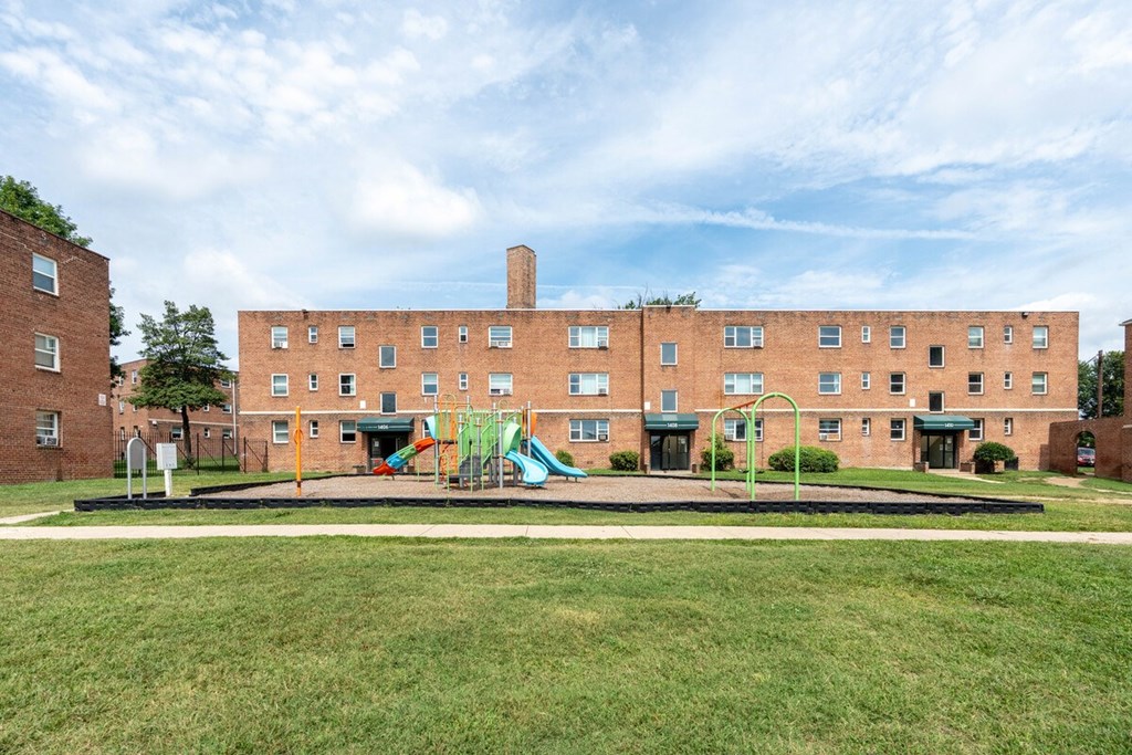A large brick building with a playground in front.
