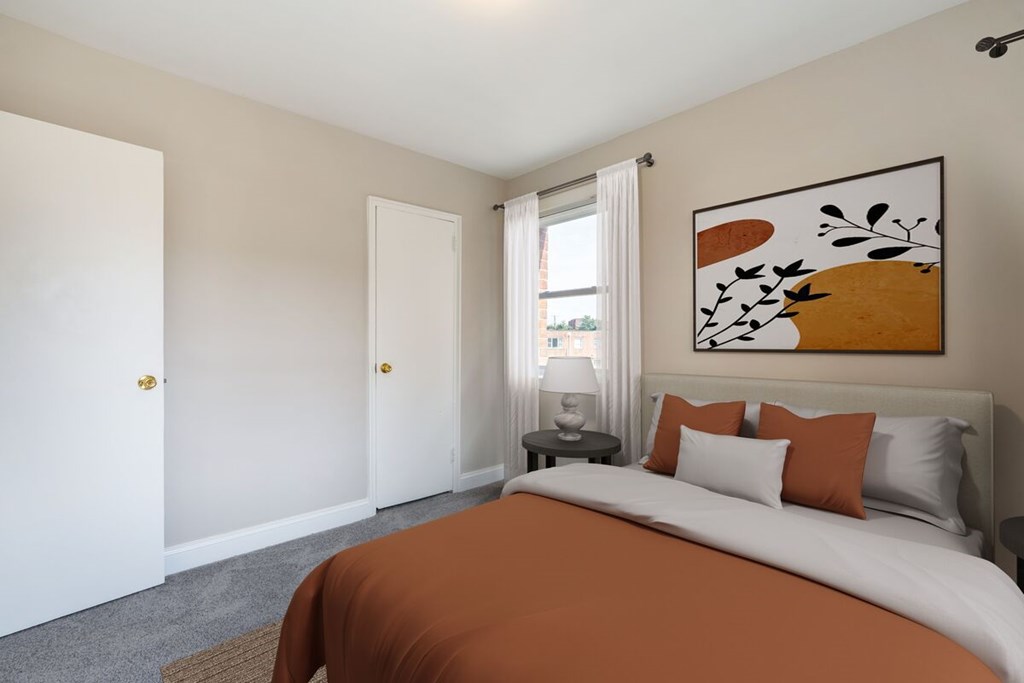 A bedroom with a large bed and a painting on the wall.