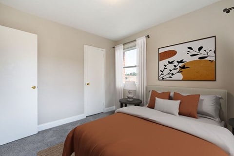 A bedroom with a large bed and a painting on the wall.