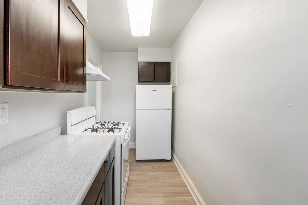 A kitchen with a white stove top oven and a white dishwasher.