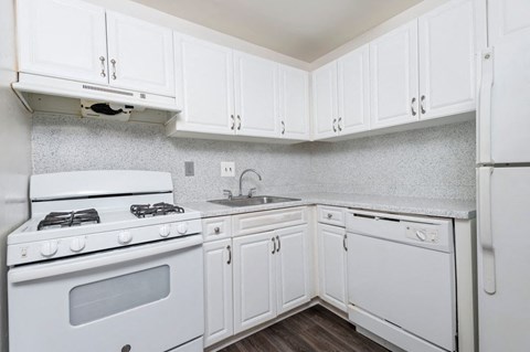 a white kitchen with white cabinets and white appliances