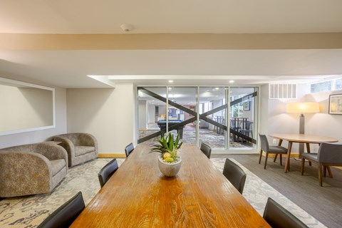 A conference room with a long wooden table and chairs.
