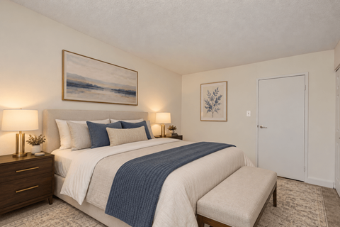 A bedroom with a large bed and a painting on the wall.