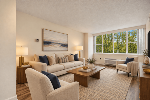A living room with a large painting on the wall and a couch with blue pillows.