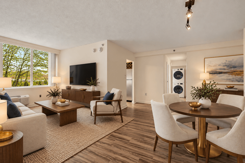 A living room with a white couch, a coffee table, and a television.