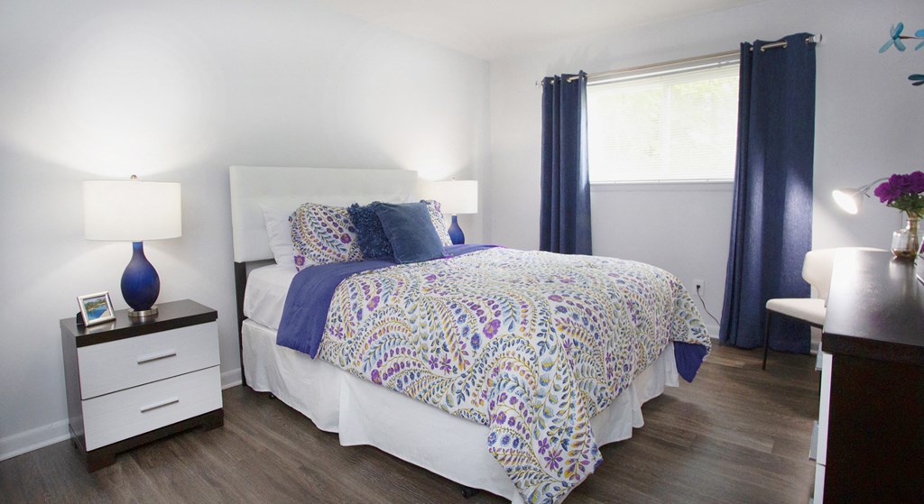 a bedroom with a bed and a dresser and a window