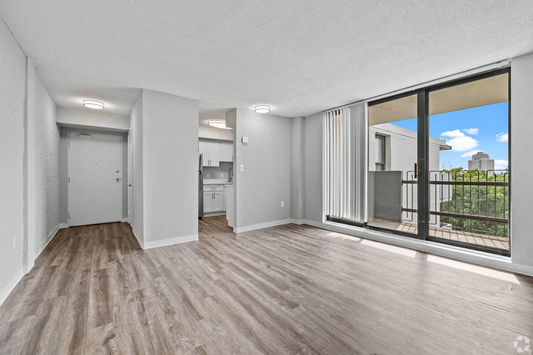 an empty living room with a large window and a balcony