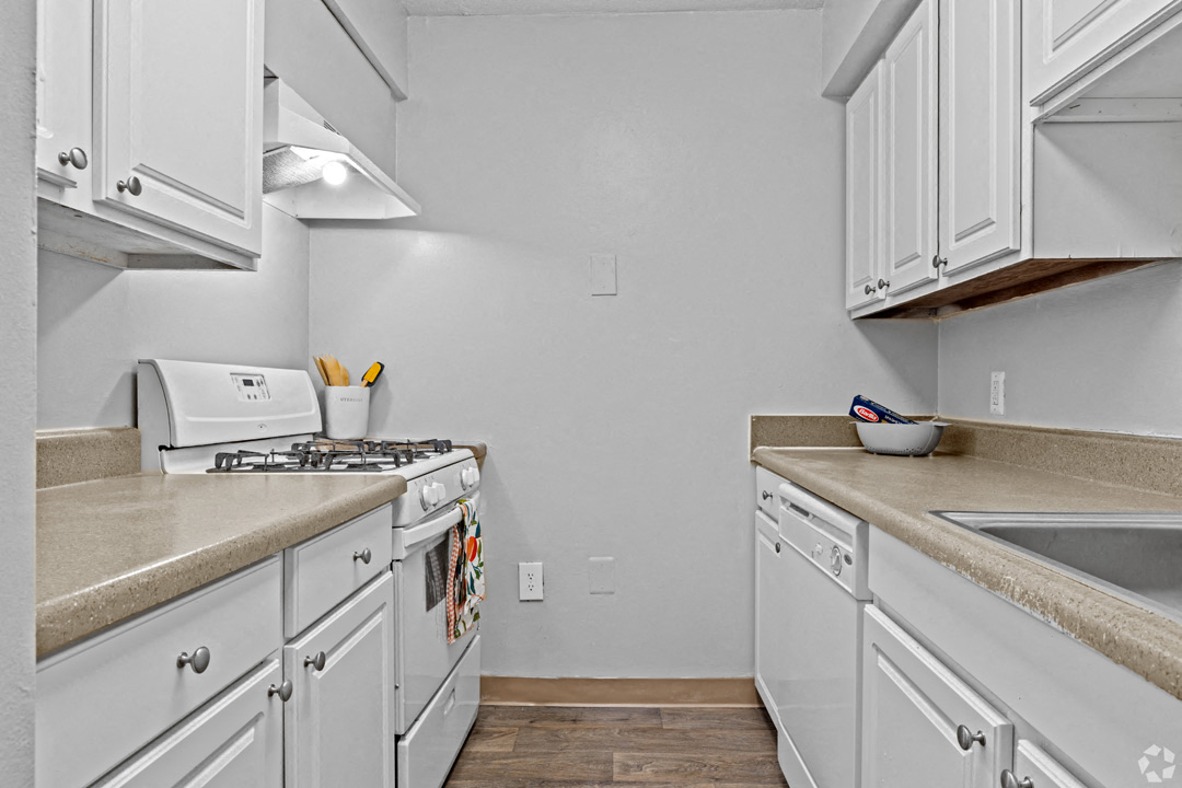 a kitchen with white cabinets and a stove and a sink