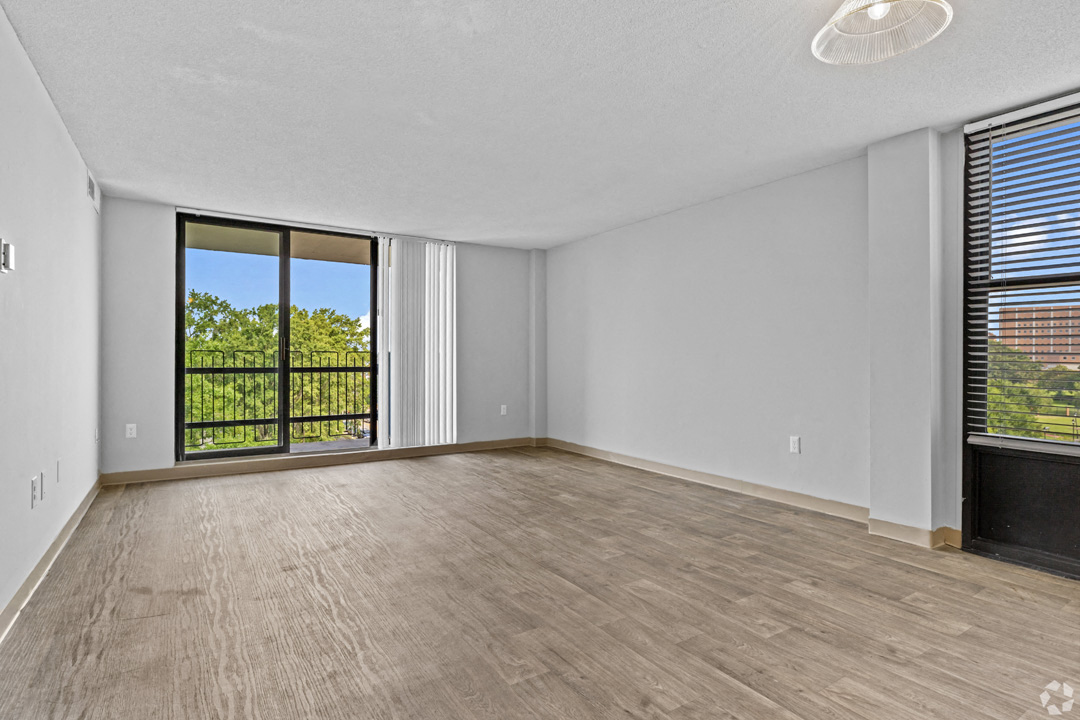 an empty living room with wood flooring and a window